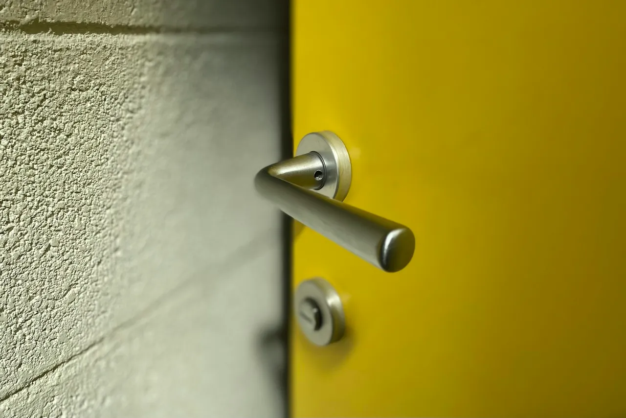 A lever handle and deadbolt on a painted interior door