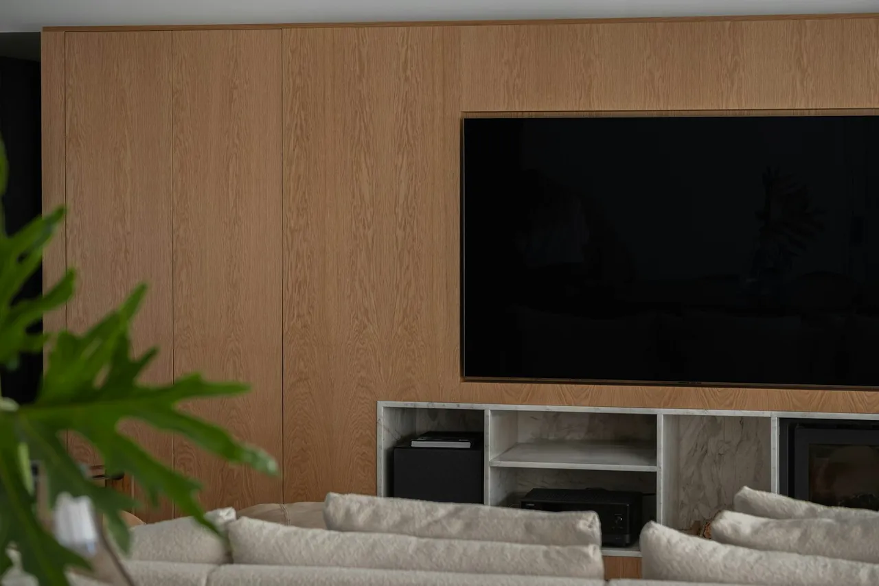 A flat-screen television mounted on a wood-panelled wall