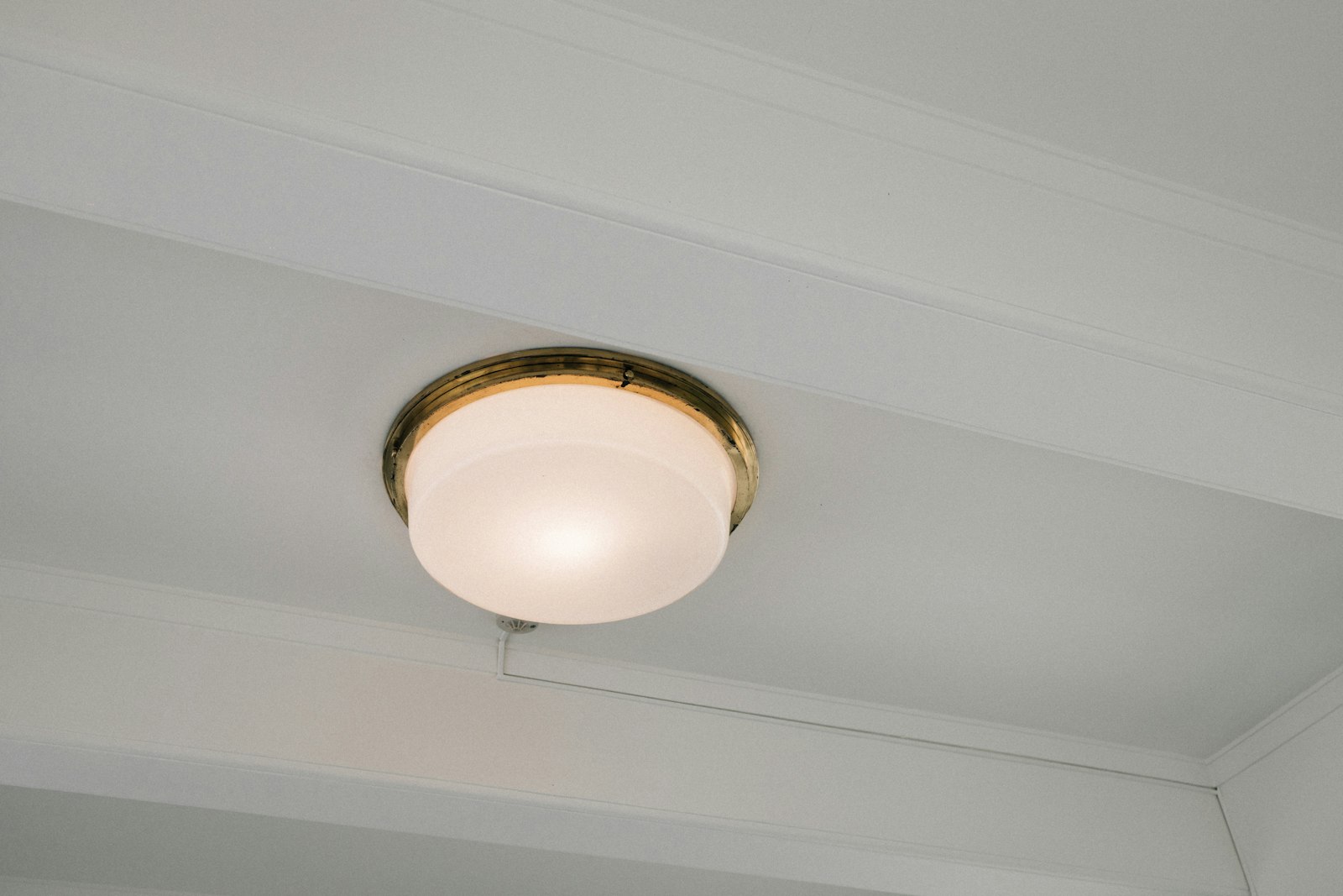 A round flush-mount light fixture on a white ceiling